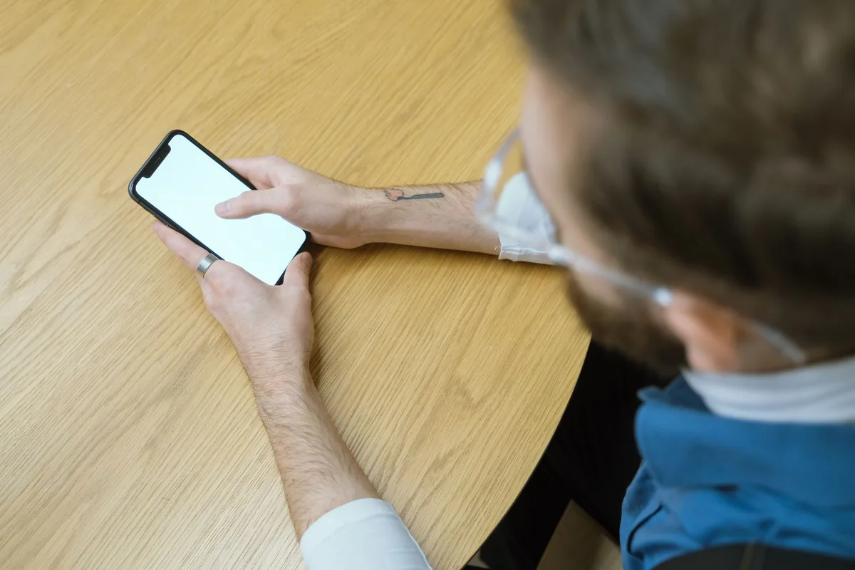 Client qui attend devant l'écran blanc de son téléphone qu'une page se charge