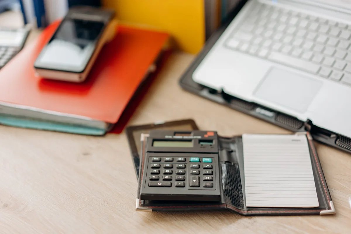 Calculatrice et factures posées sur le bureau d'une petite entreprise